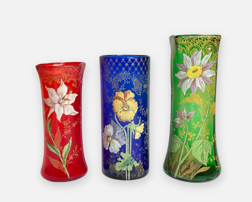 Drei französische Glasvasen mit Blütenmotiv in den Farben Rot, Blau und Grün.